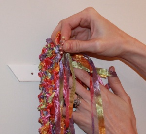 Line up scarf with top ledge of hanger. Use straight pins to attach.
